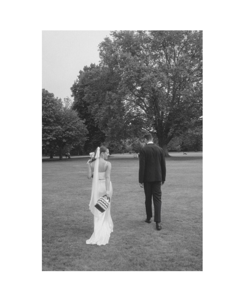 Candid photo of couple walking into the distance on their wedding day. Photo by London Wedding Photographer, Pia Bacino