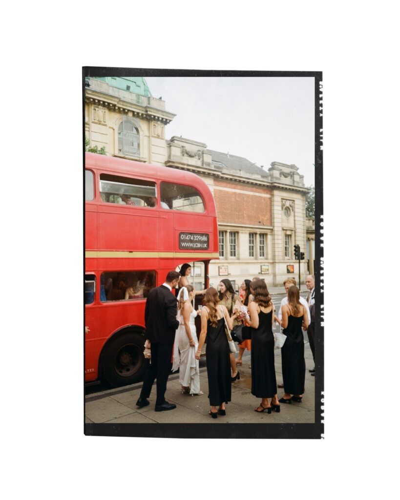 Wedding party waits to get onboard a classic London red bus. Photo by London Wedding Photographer, Pia Bacino taken on 35mm film