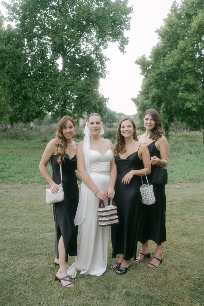 Bride and her bridesmaids looking radiant on wedding day holding pearl bags. Photo by London Wedding Photographer, Pia Bacino