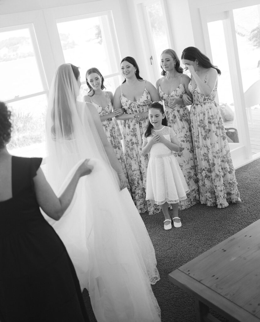 Bridesmaids and flower girl see Bride for the first time. Wedding at Poderi Crisci in Waiheke Island, Auckland