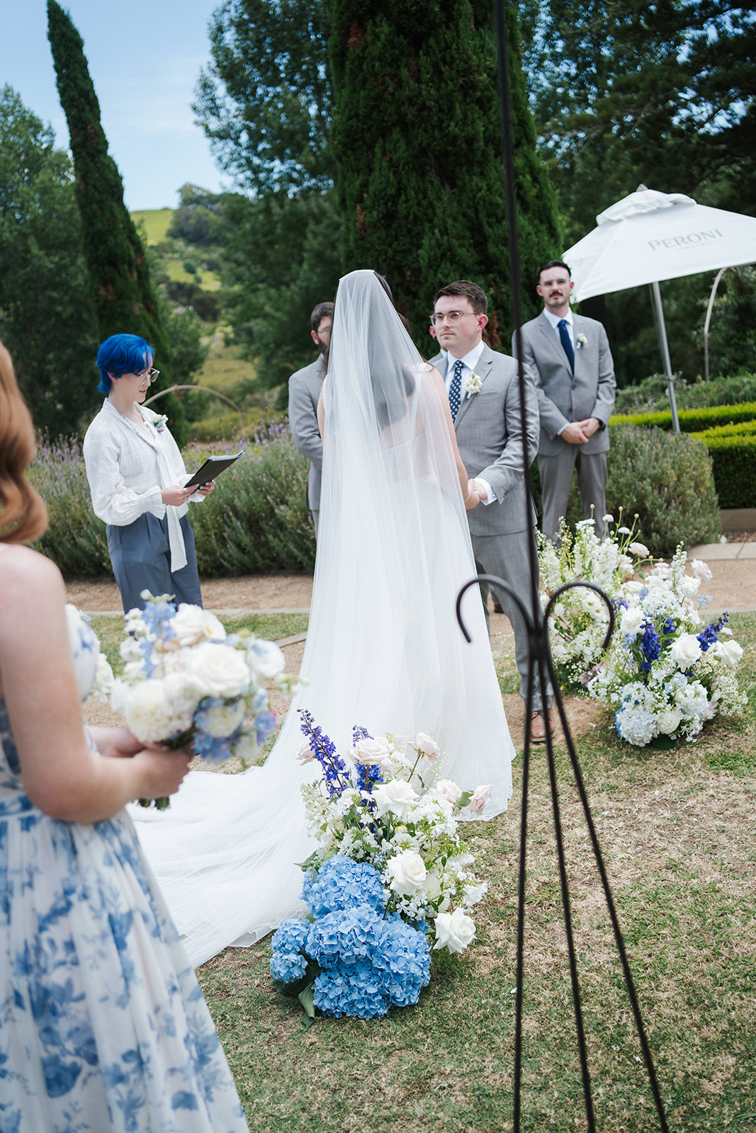 Elegant couple standing at their wedding ceremony at Poderi Crisci in Waiheke Island surrounded by their friends and family