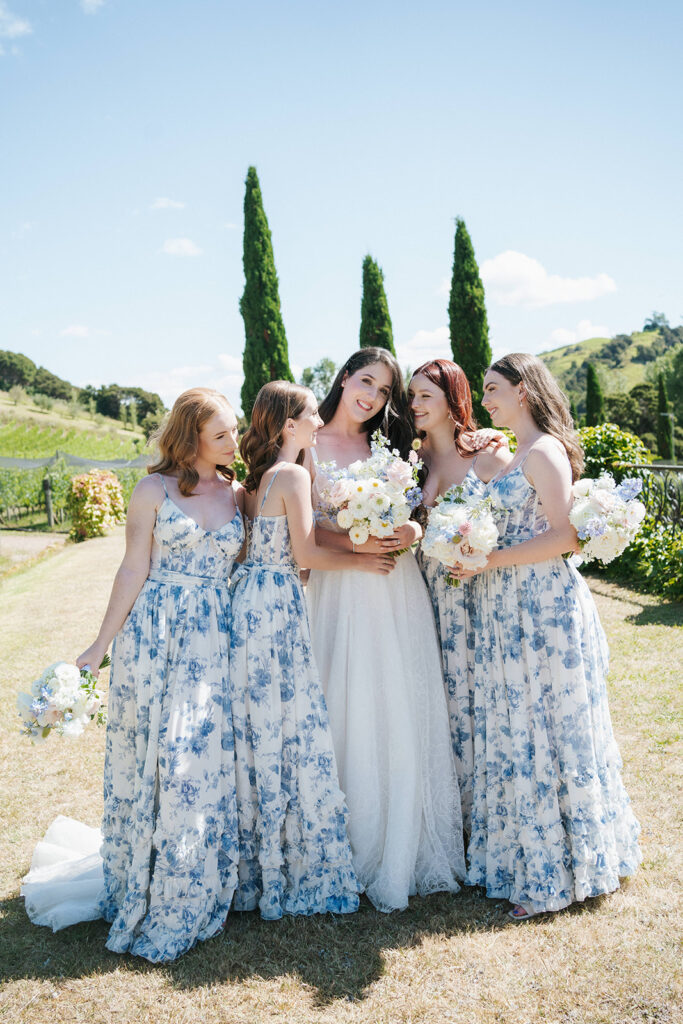 Bridesmaids wearing floral blue dresses and Bride at Wedding at Poderi Crisci in Waiheke Island, Auckland